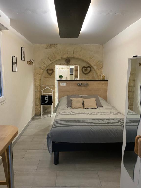 une chambre avec un lit et un mur en pierre dans l'établissement Studio Numéro 3, à Villeneuve-lès-Avignon