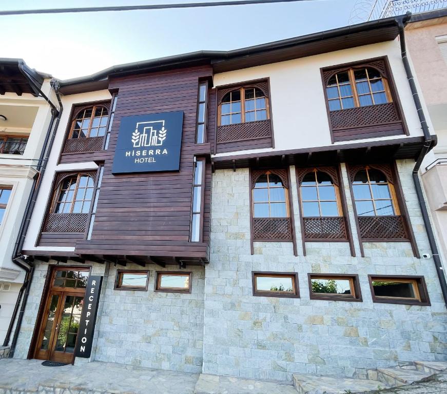 un bâtiment avec un panneau à l'avant dans l'établissement Hotel Hiserra, à Prizren