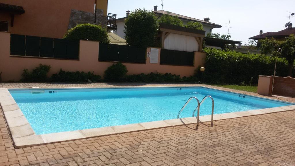 a swimming pool in front of a house at Appartamenti Fiordaliso in Sirmione