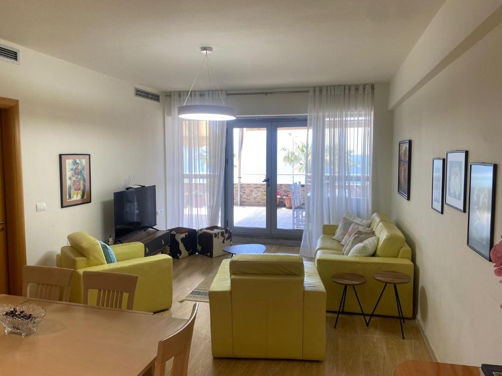 uma sala de estar com mobiliário amarelo e uma mesa em Cactus Coastal: 3-Bedroom Condo II em Vlorë