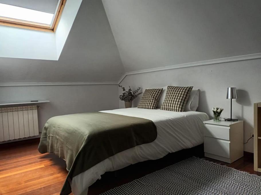 sypialnia z dużym łóżkiem i oknem w obiekcie Ático luminoso con terraza w mieście Santander