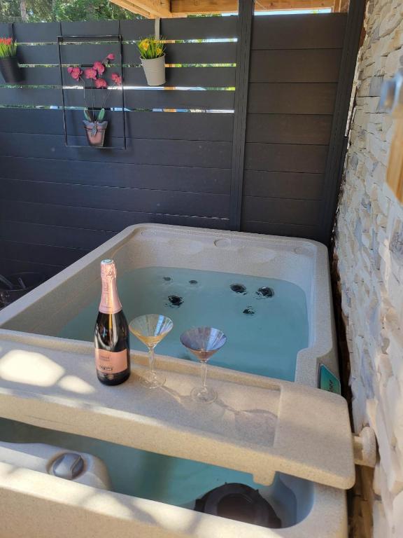 - une baignoire avec deux verres et une bouteille de champagne dans l'établissement les marmottes, à Gérardmer