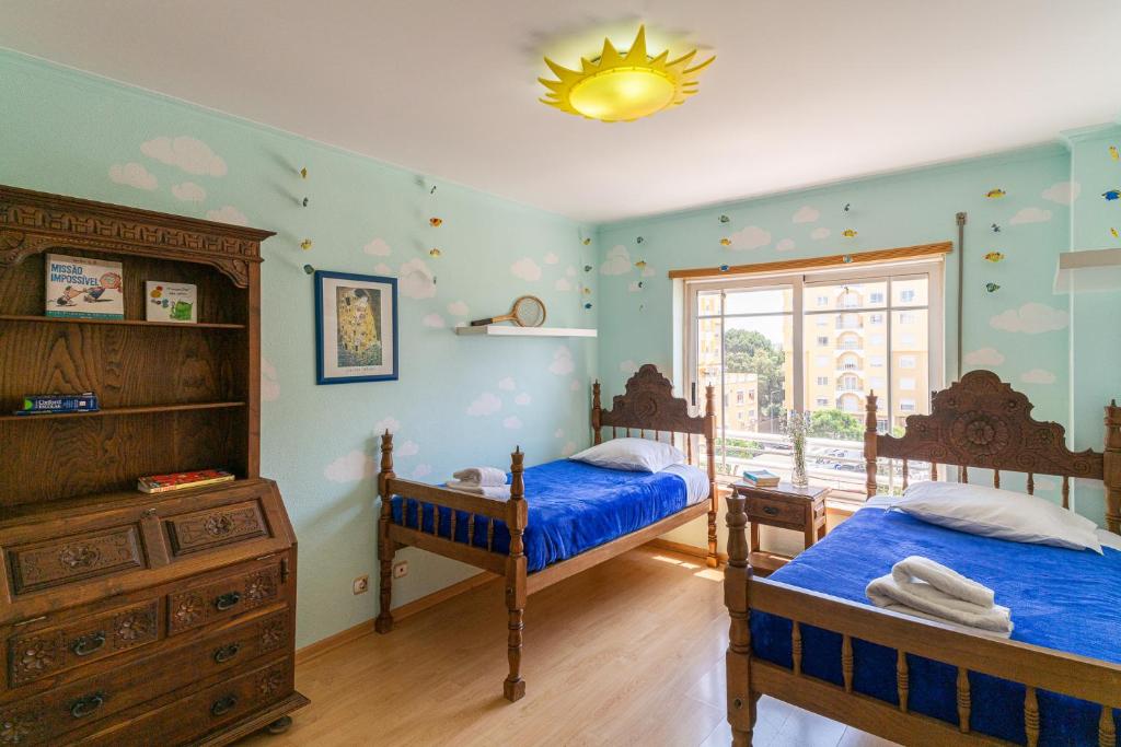 um quarto com 2 camas e uma cómoda e uma janela em Family Comfort House no Seixal