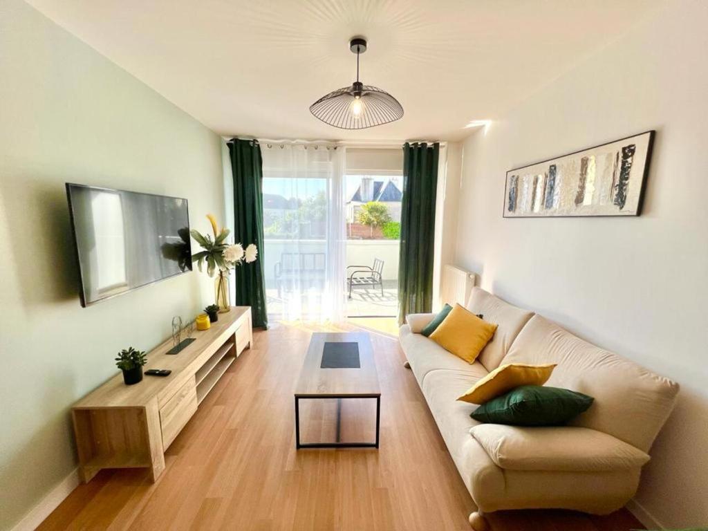 uma sala de estar com um sofá e uma mesa em Lanester - Le Parc à bois - Wifi Fibre - Balcon - Parking privé em Lanester