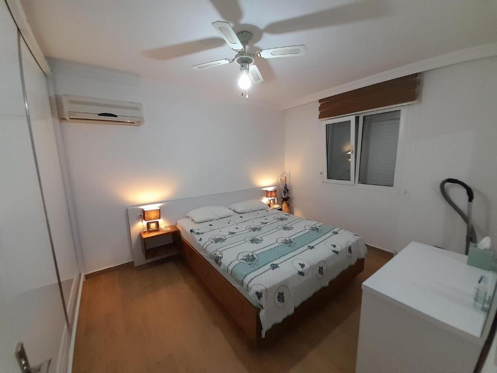 1 dormitorio con 1 cama y ventilador de techo en Villa suzi, en Aydın