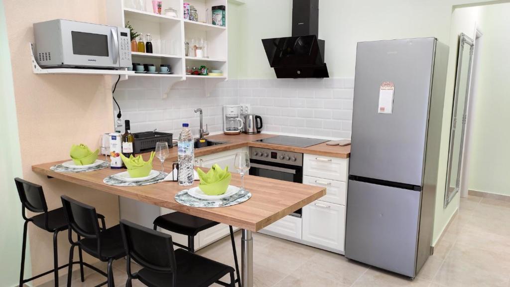 a kitchen with a table with chairs and a refrigerator at Sea Esta 2 bedroom by the beach in Perea