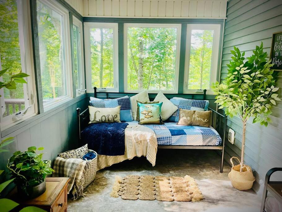 Habitación con sofá en una habitación con ventanas en Stunning Lake front home with stunning decor, en Mill Spring