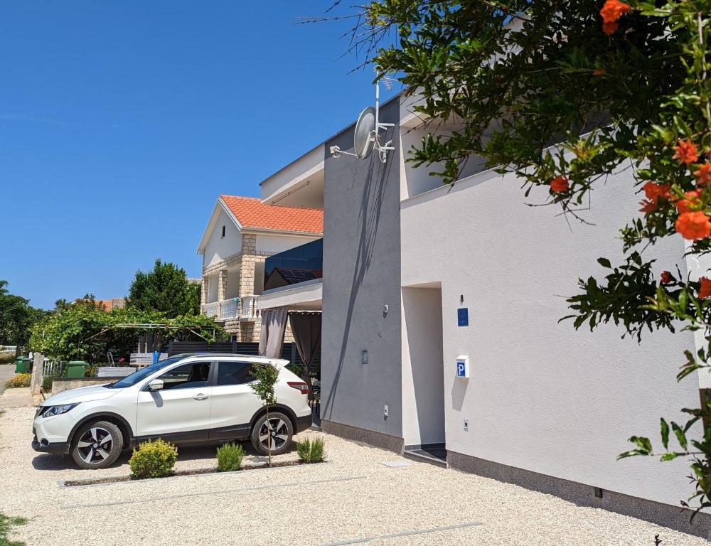 ZILIP Apartments في فير: سيارة بيضاء متوقفة أمام منزل