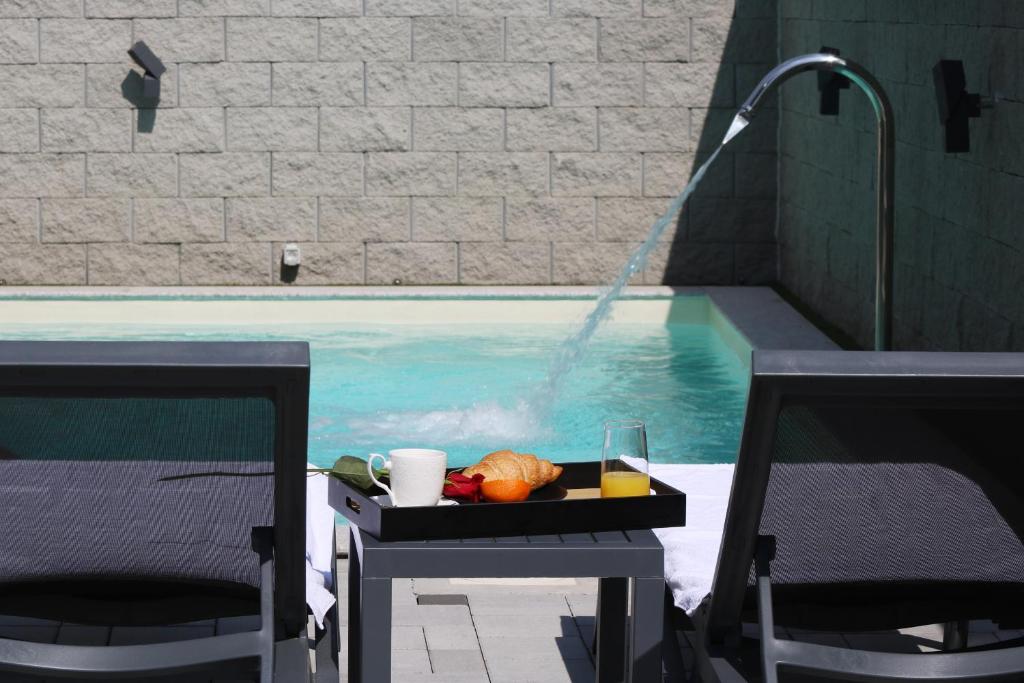 een dienblad met eten op een tafel naast een zwembad bij Avangard HOME I 