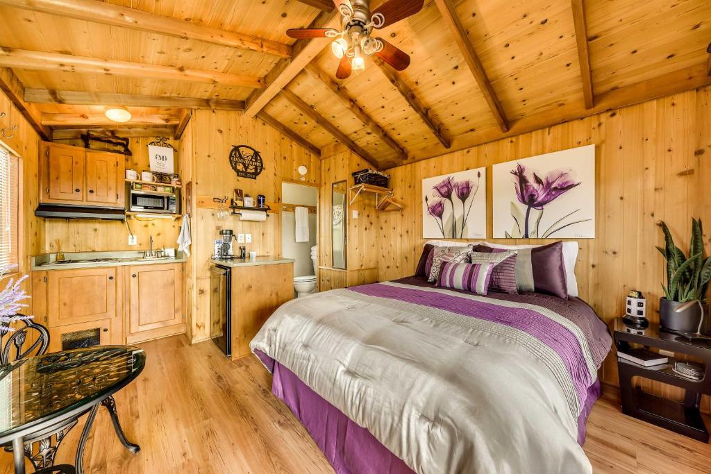 1 dormitorio con 1 cama y cocina en una cabaña en Mayhill Tiny Home Vacation Rental with Covered Porch en Mayhill
