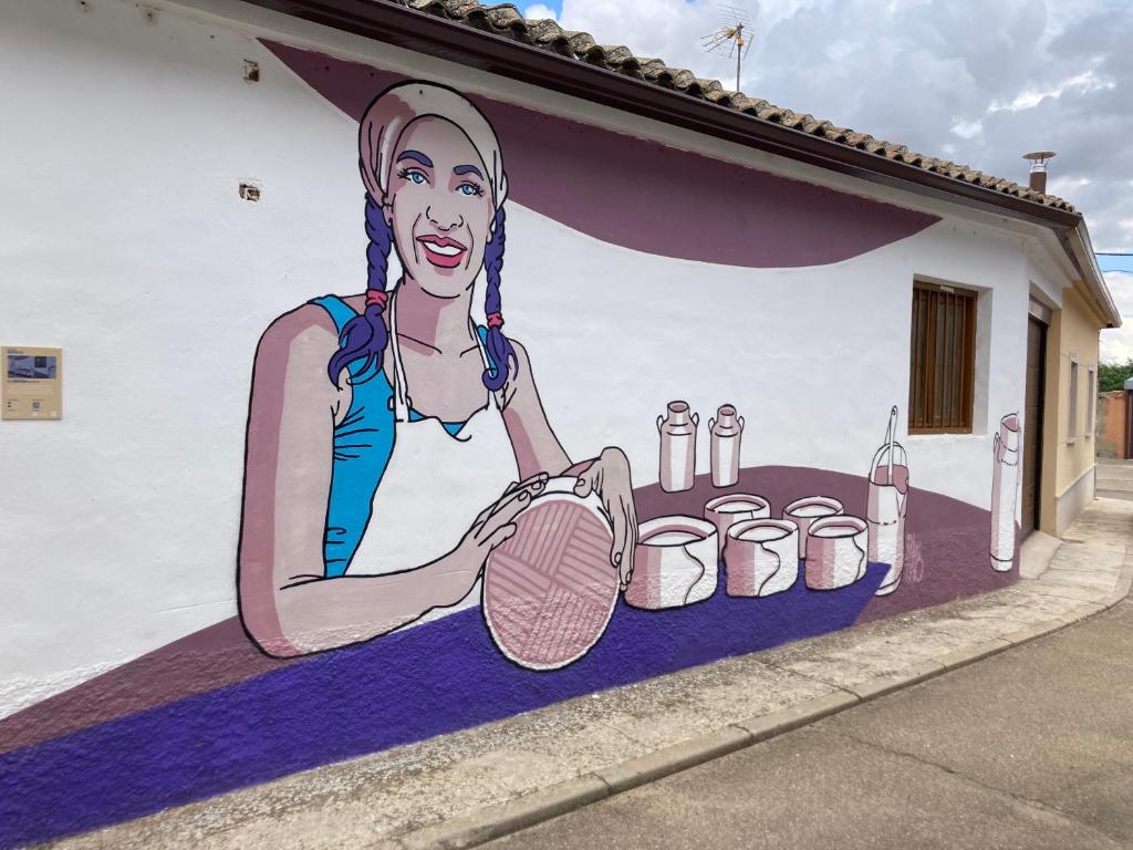 a mural of a woman holding a tennis racket at La Quesería in Villaherreros