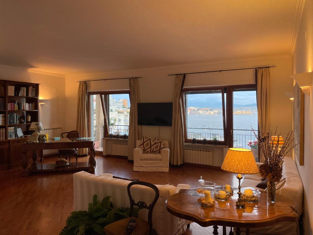 ein Wohnzimmer mit einem Tisch und Meerblick in der Unterkunft Panoramico a Posillipo in Neapel