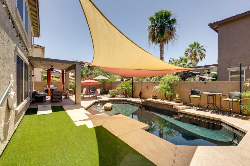 a backyard with a swimming pool with a hammock over it at Goodyear Home with Heated Pool, Near Spring Training in Goodyear