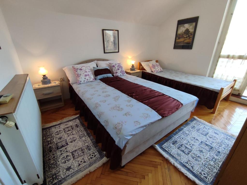 a bedroom with two beds and two rugs at Smestaj Vella in Herceg-Novi