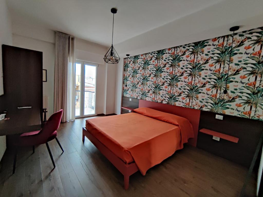 - une chambre avec un grand lit orange et un bureau dans l'établissement BeBari Apartments, à Bari