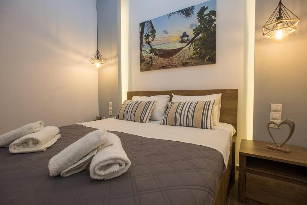 a bedroom with a bed with towels on it at Coastline of paradise 2 in Paránimfoi