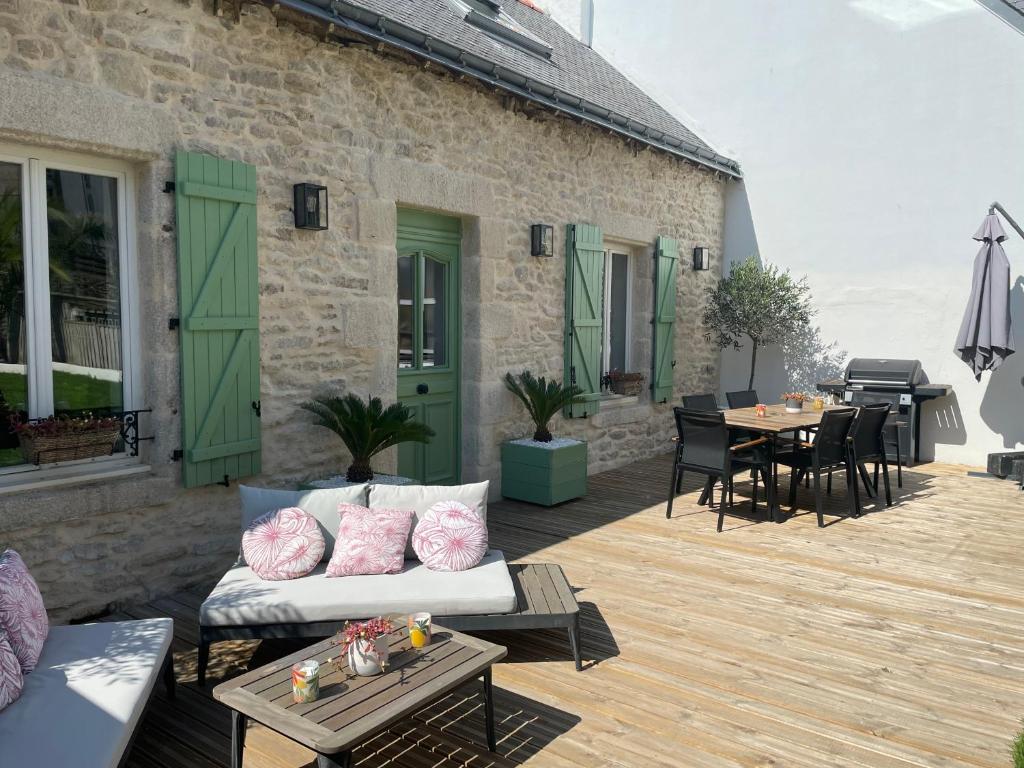 um pátio com um sofá e uma mesa num deque em Bella Vita Maison de charme au design soigné em Lorient