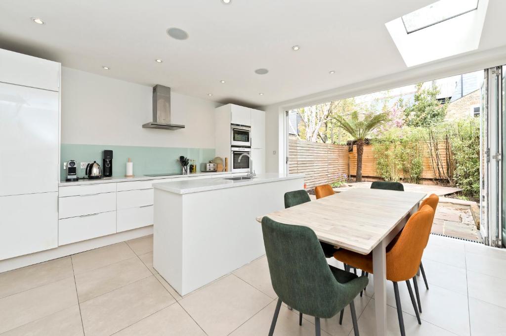 a kitchen and dining room with a table and chairs at Family Home near Clapham Common by UnderTheDoormat in London