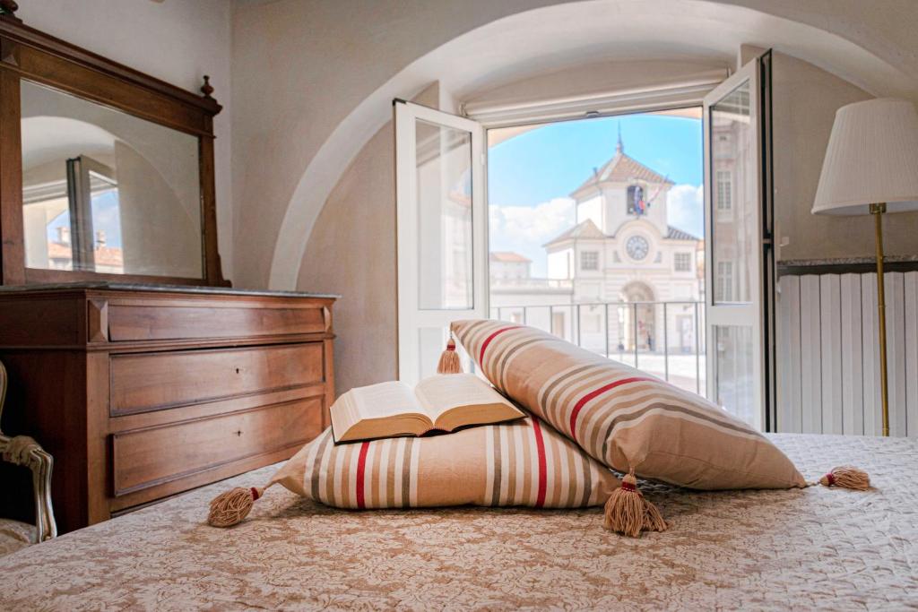 - une chambre avec un lit, un livre et une fenêtre dans l'établissement CASA ROYAL sulla Reggia di Venaria, à Venaria Reale