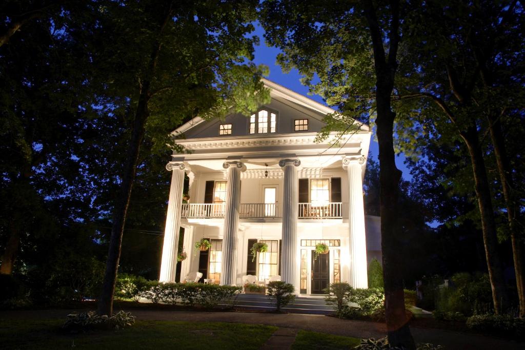 a large white house with a porch at night at The Inn at Cape Cod in Yarmouth Port