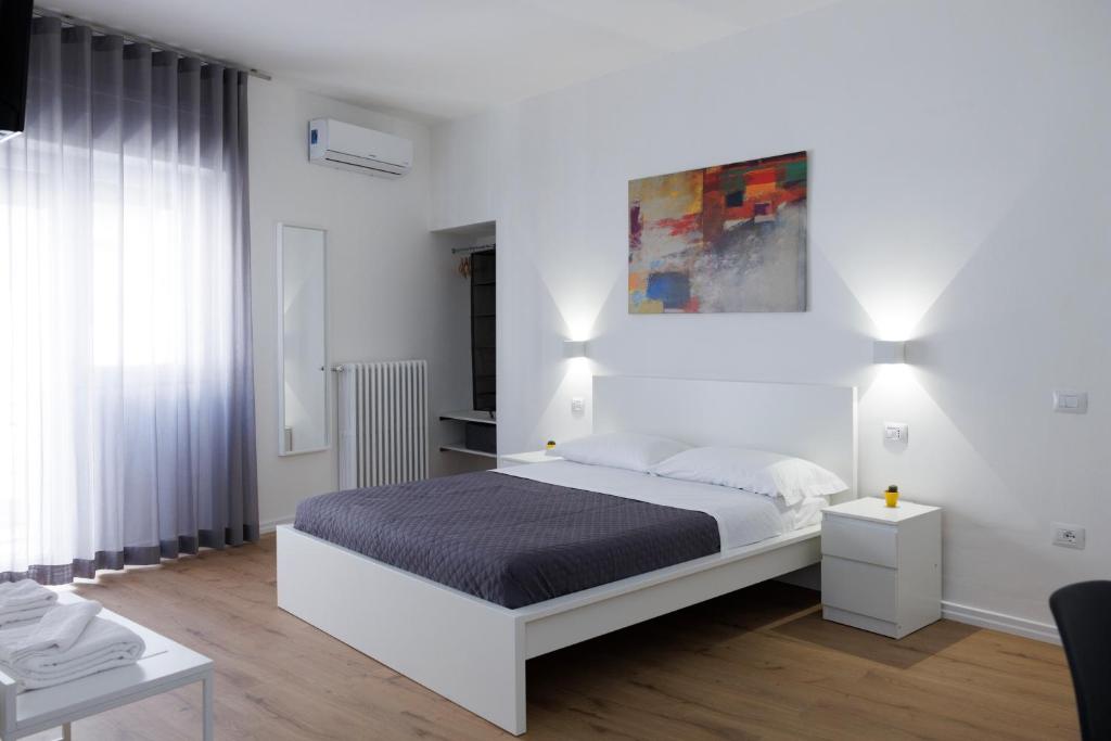 una camera da letto bianca con un letto e una finestra di B&B In Piazza a Mafalda