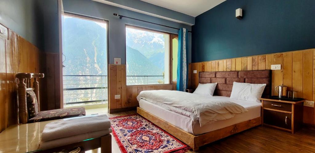 a bedroom with a bed and a large window at Rudra homestays in Kalpa
