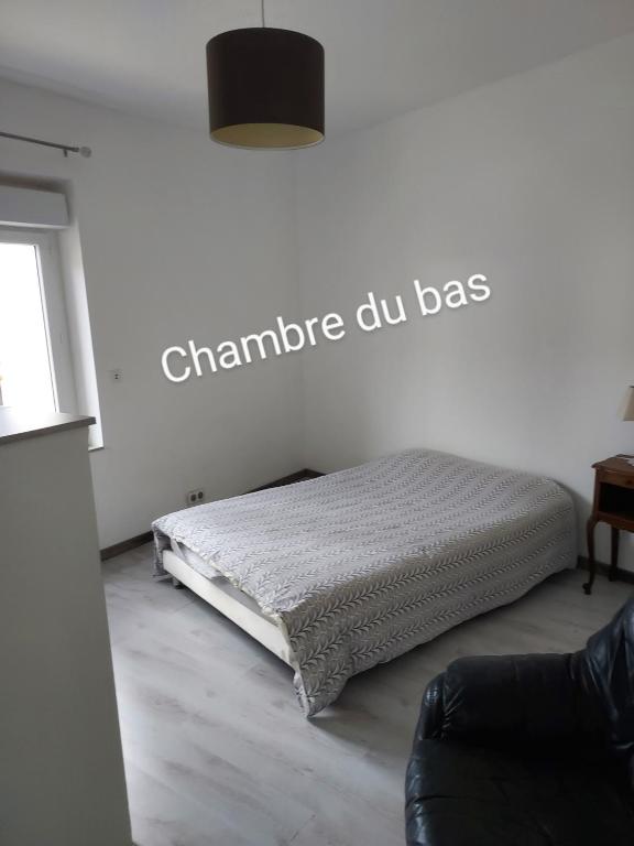 łóżko w pokoju z napisem na ścianie w obiekcie La Chaumière de Medee 