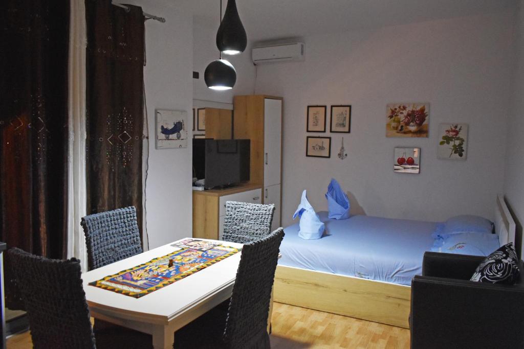 um quarto com uma cama, uma mesa e cadeiras em Sea Salt Studio Apartment em Vlorë