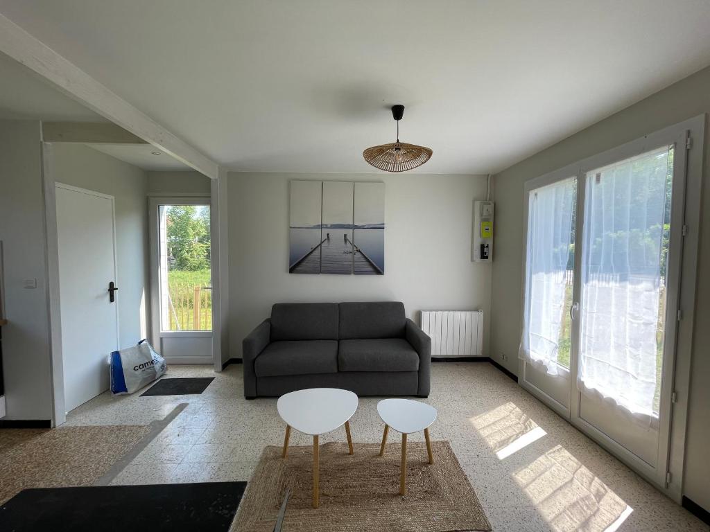 un salon avec un canapé et deux tables dans l'établissement Les Lucioles Fort-Mahon Plage, à Fort-Mahon-Plage