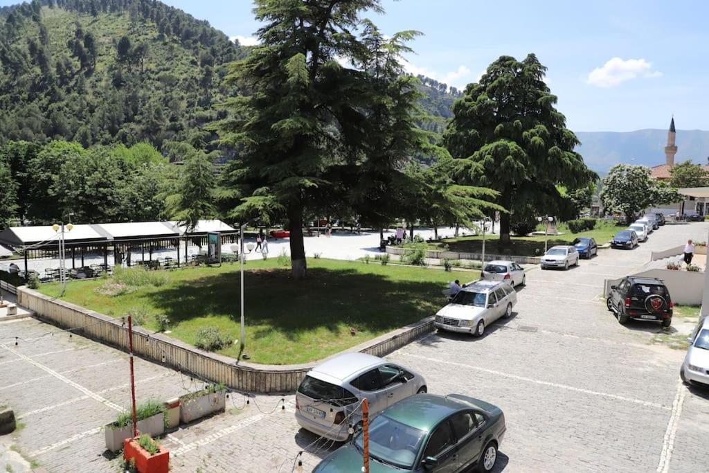 un parking avec des voitures garées devant un bâtiment dans l'établissement Blei & Dei Apartment, à Berat