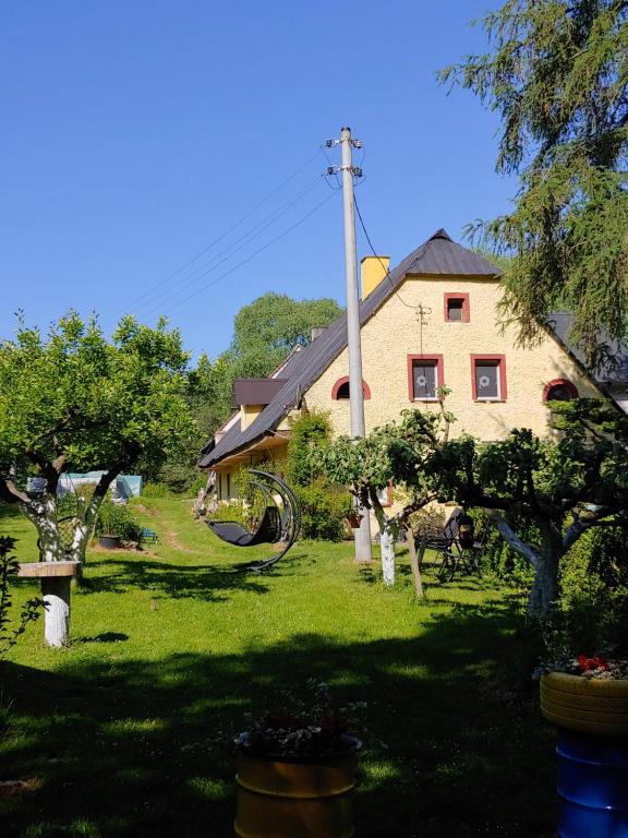 a house with a yard with trees in front of it at Agroturystyka Zacisze in Gorzanów