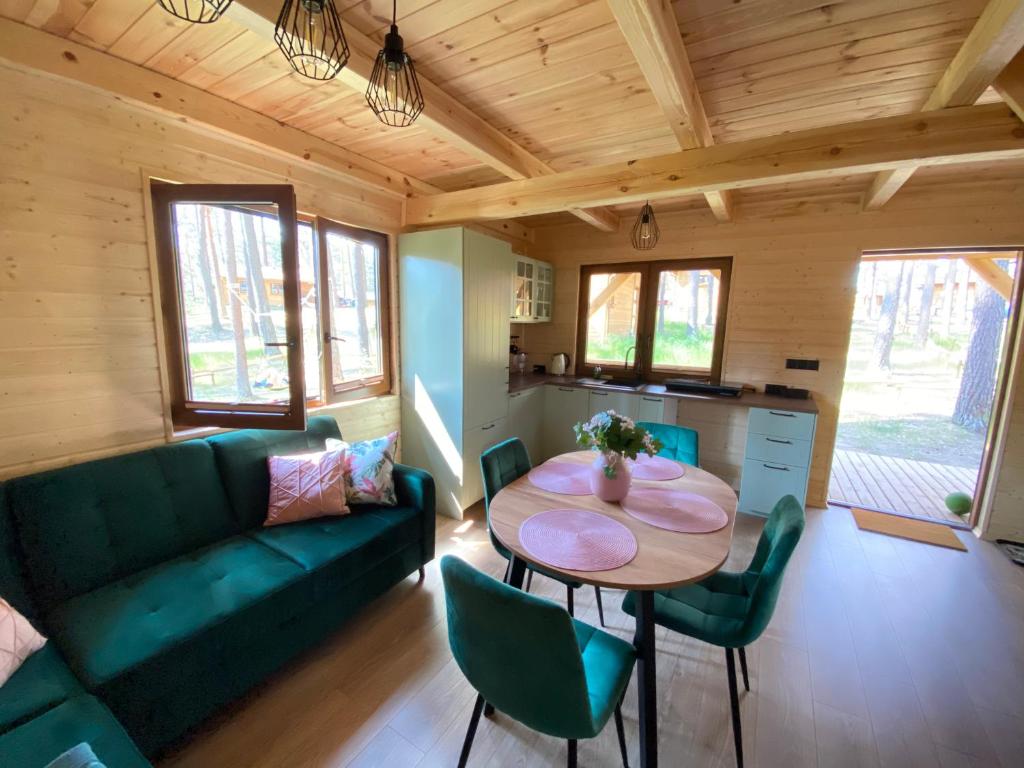 uma sala de estar com um sofá verde e uma mesa em Chëcz u Wéłka em Borsk