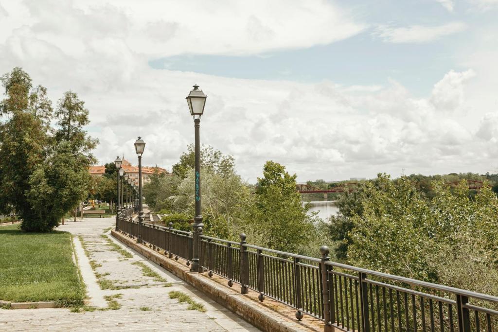 uma ponte sobre um rio com duas luzes de rua em Casa a 3 minutos del Casco y con facil aparcamiento- El rincón de Carmela em Talavera de la Reina