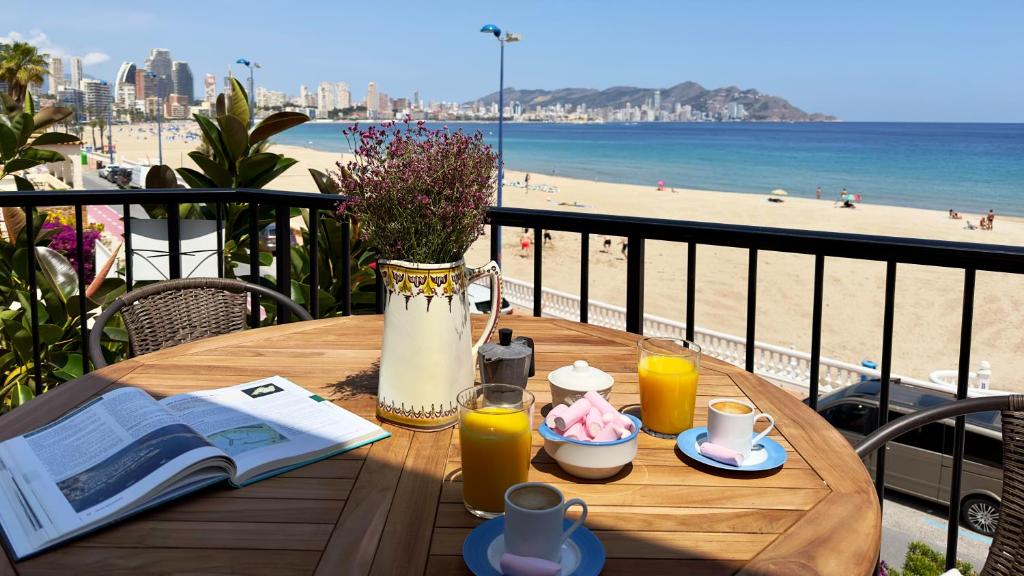 a table on a balcony with a view of the beach at PARRALUE Beach front home in Benidorm