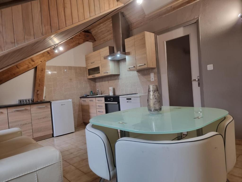 a kitchen with a table and two white chairs at Embrun Cosy in Embrun