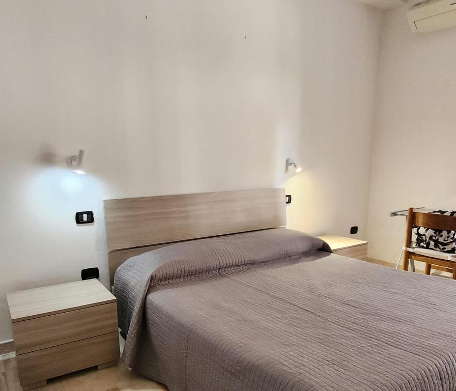 a bedroom with a large bed and a chair at Sicily Guest House in Gela