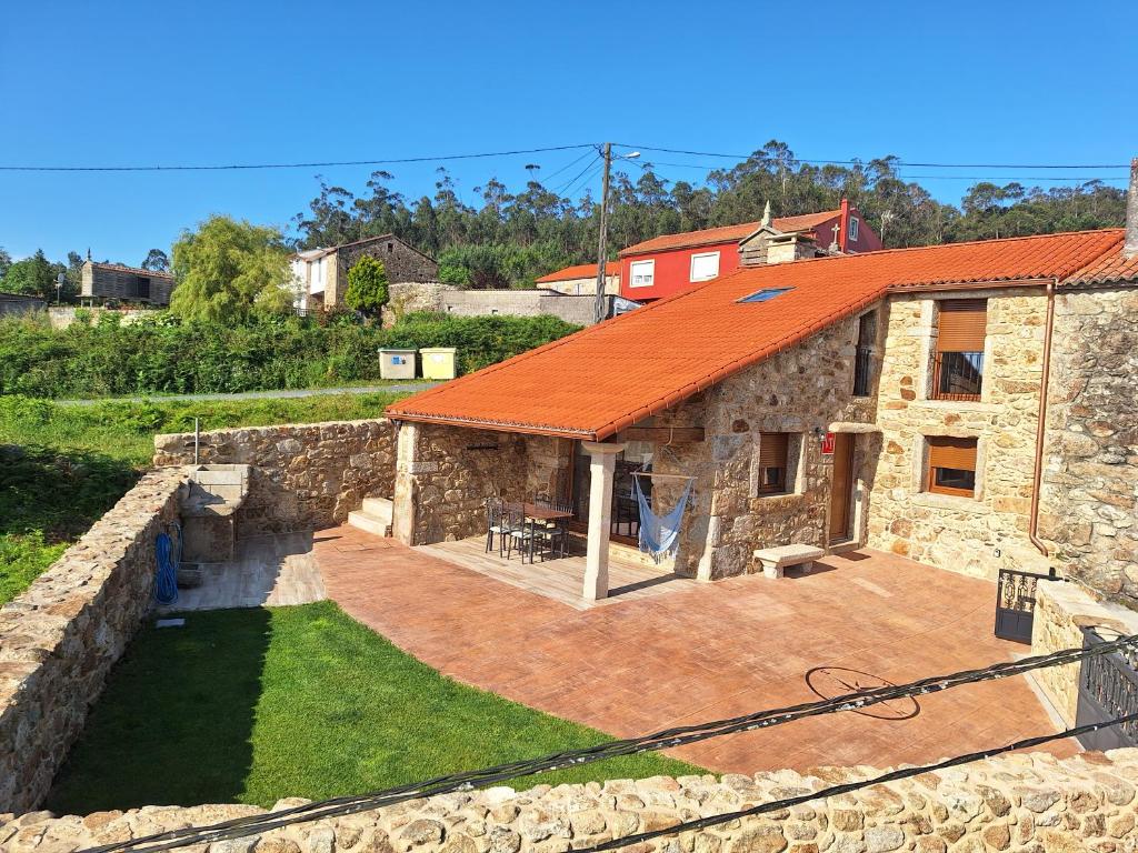 a stone house with an orange roof at A casa dos Pobres in Muxia