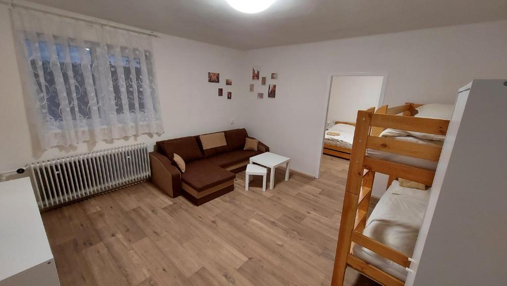 ein Wohnzimmer mit einem Sofa und einem Etagenbett in der Unterkunft Apartmán Velehrad in Velehrad