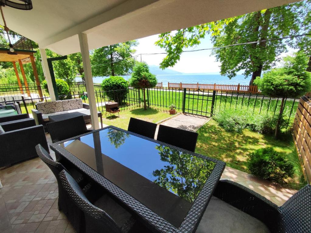 einen Tisch und Stühle auf einer Terrasse mit Meerblick in der Unterkunft Villa Paradiso in Ohrid