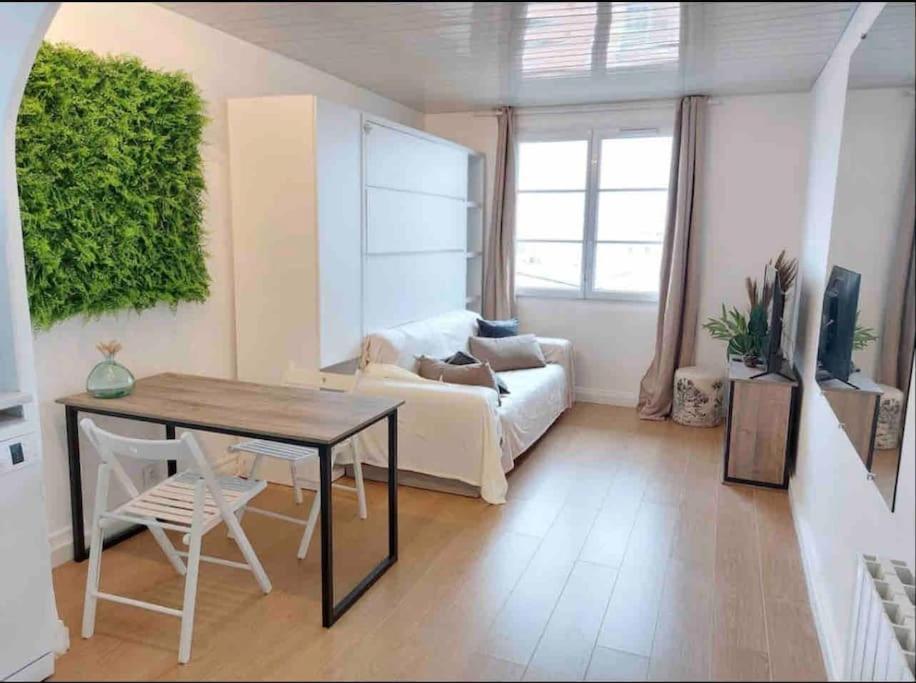 a living room with a table and a couch at Vue MER/Tout à pied/Calme/Plage/ Parc Mauresque in Arcachon