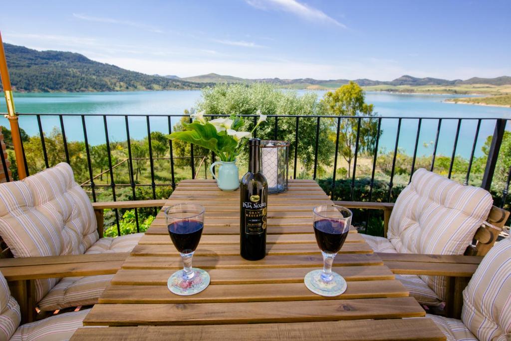 a wooden table with two glasses of red wine at El Arpa in El Chorro