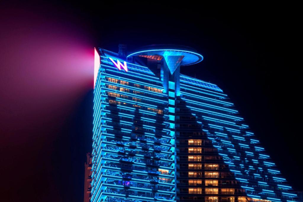 a tall building with a visa sign on it at night at W XIAN Hotel in Xi'an