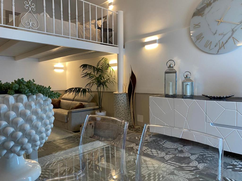ein Wohnzimmer mit einer Uhr und einer Couch in der Unterkunft White Pearl - Luxury in Giardini-Naxos