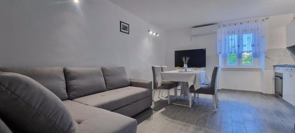 a living room with a couch and a table at Apartment Z in Zlarin