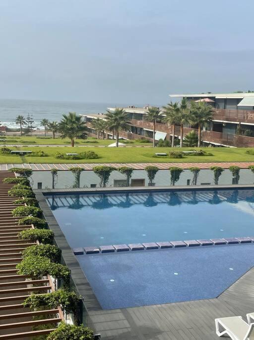 - une vue sur la grande piscine bordée de palmiers dans l'établissement Nice appartement pool & sea view, à Dar Bouazza