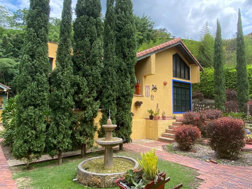 une maison avec une fontaine en face d'une cour dans l'établissement Finca Australia, à Quebradanegra