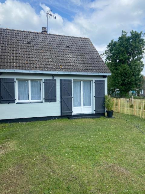 une maison blanche avec une clôture et une cour dans l'établissement Les Lucioles Fort-Mahon Plage, à Fort-Mahon-Plage