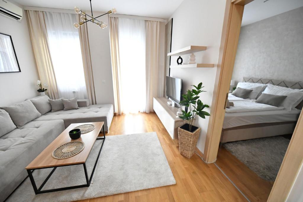 a living room with a couch and a bed at Apartman SUN in Inđija