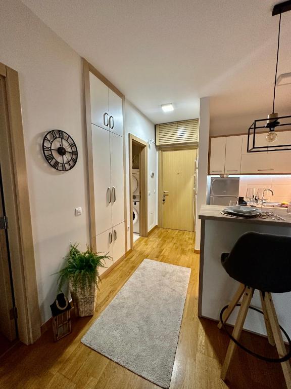 a kitchen with a counter and a clock on the wall at Apartman SUN in Inđija