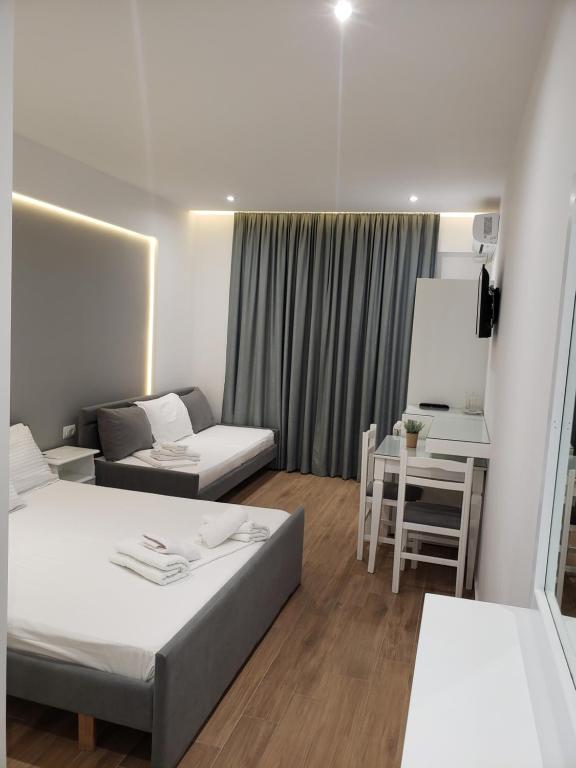 Zimmer mit 2 Betten, einem Sofa und einem Tisch in der Unterkunft Vila 31 in Sarandë